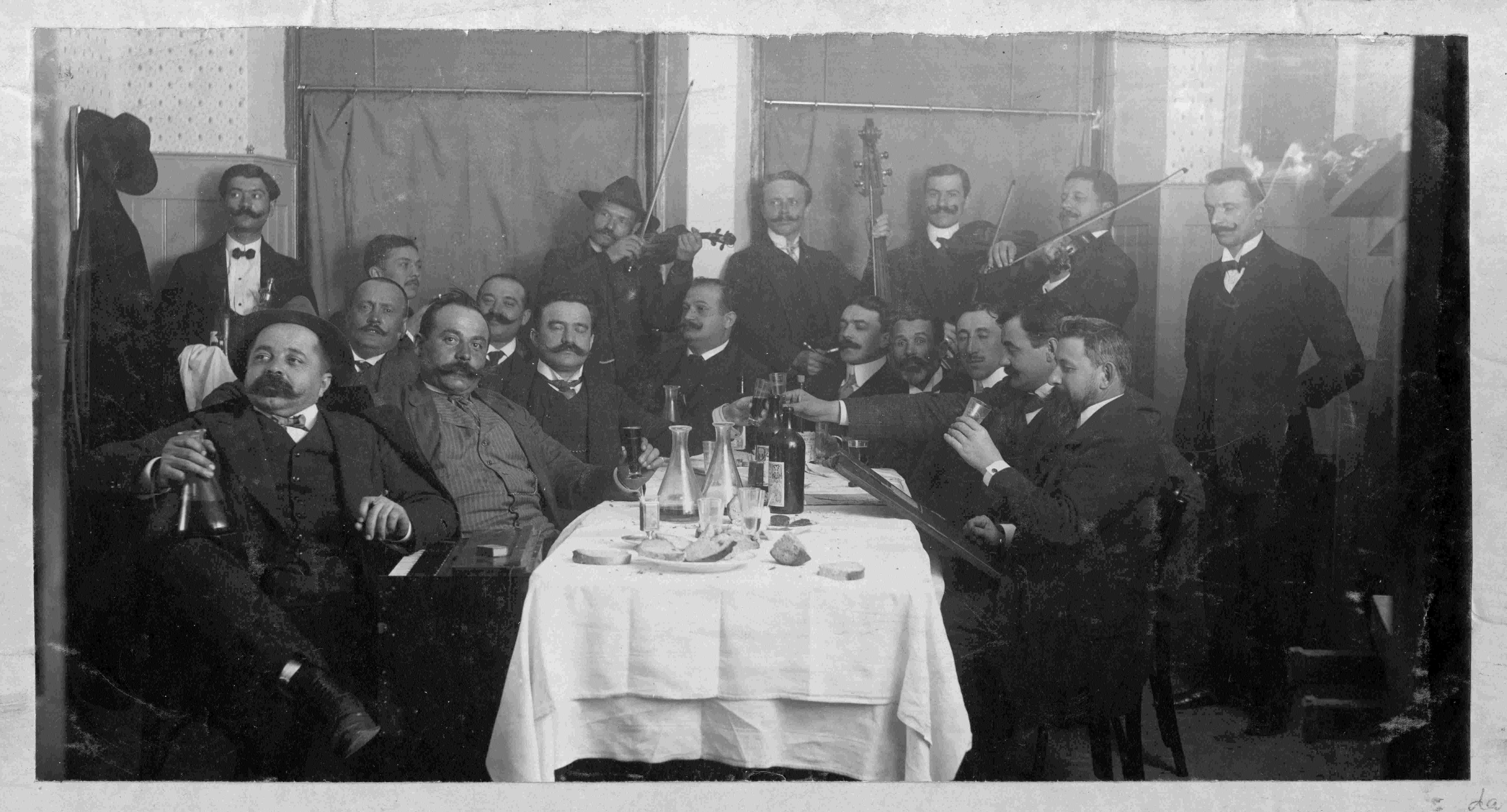 Petrović (violinist with the hat) conducts the musical band “Suz” during a tavern party. (SASA Archive, 14197/1)